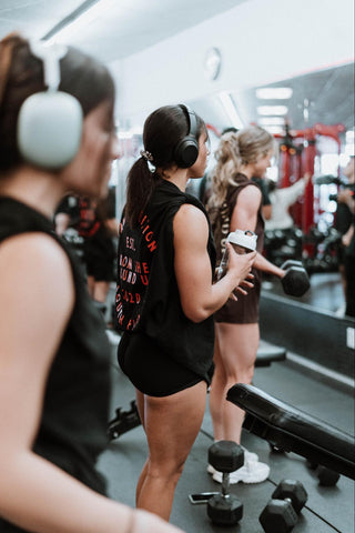 A woman in the gym, holding a shaker bottle