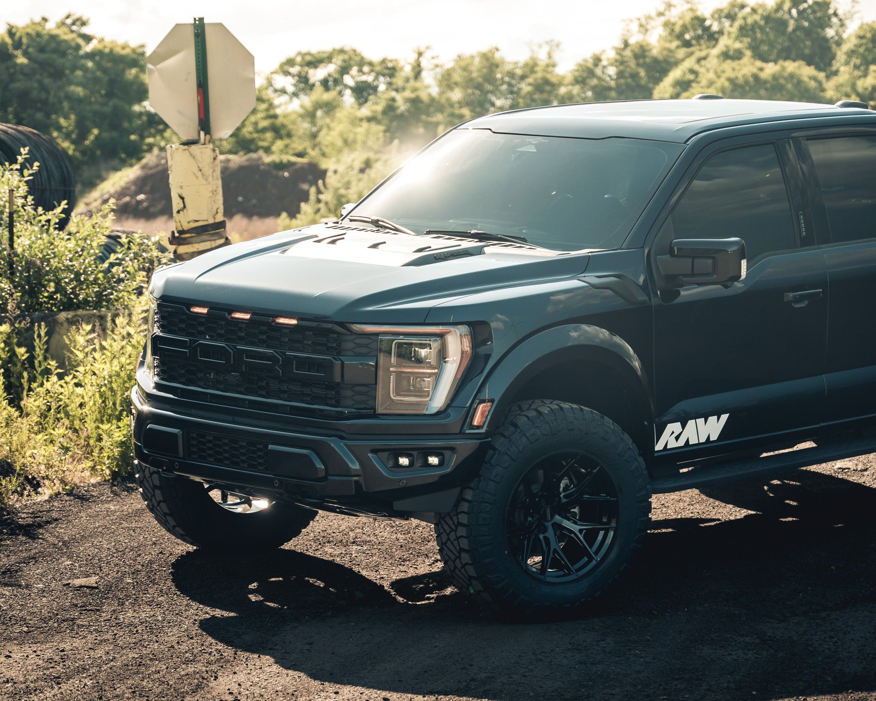 Black pickup truck parked outdoors with the word 'RAW' on the side.