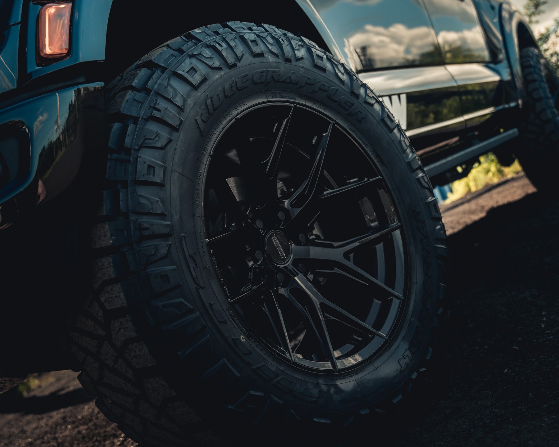 Close-up of a vehicle's off-road tire and alloy wheel.