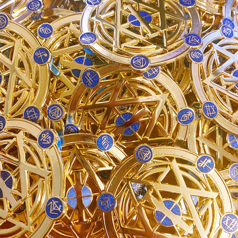 A bunch of gold die cut pins