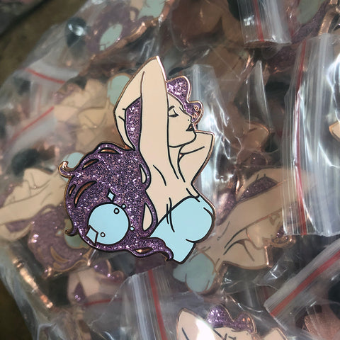 A pin of a beautiful woman with glittery lavender hair