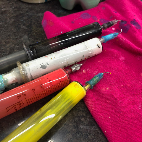 several brightly colored syringes full of enamel