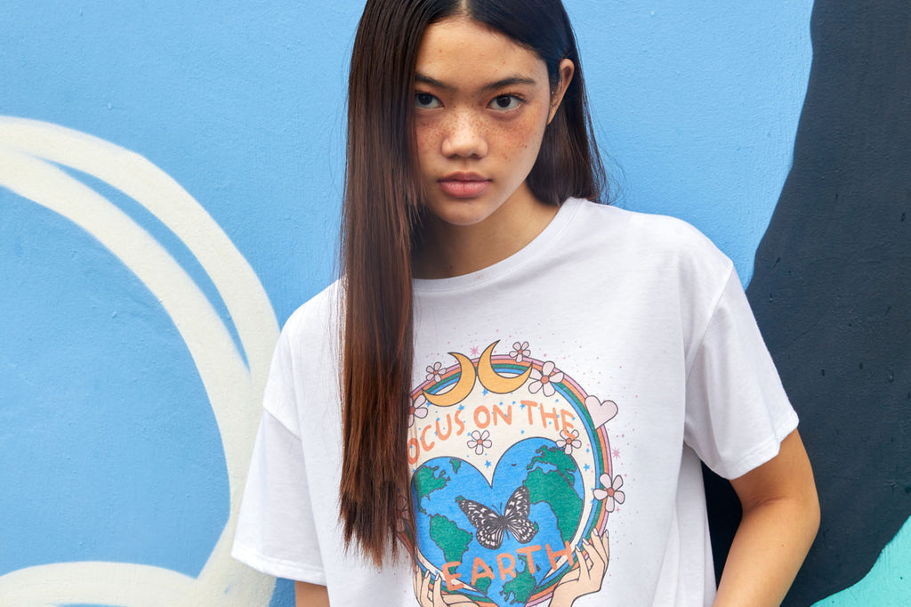A young girl wearing Gen Woo ‘Focus on the Earth’ graphic print slogan t-shirt.