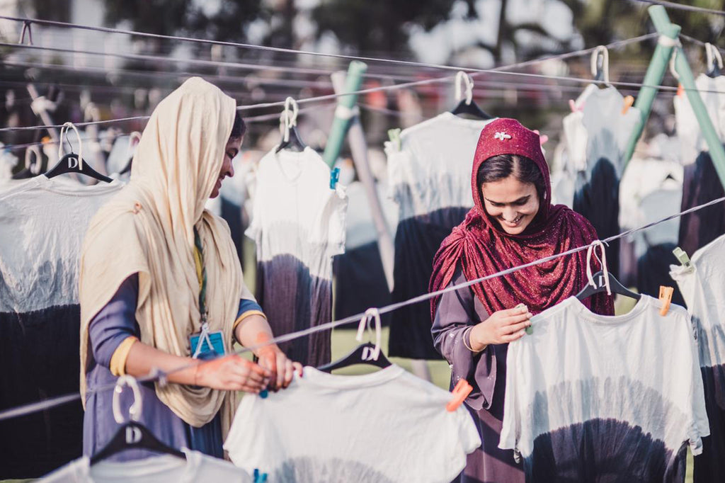 Garment workers hanging to dry tie dye t-shirts