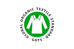A white shirt on circular green background, encompassed by the GOTS title.