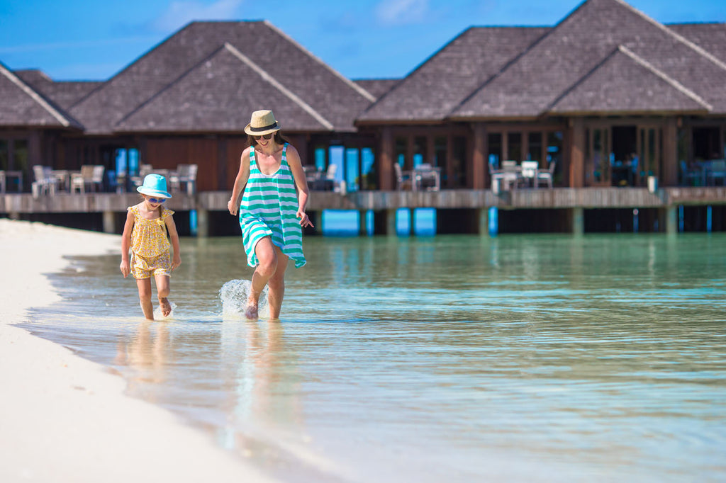 Girl in ditsy printed romper walking along the beach