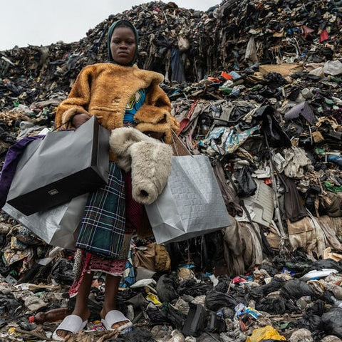 A local woman standing in a textile landfill in Ghana. Image: The REVIVAL (V&A)