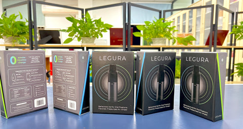 Five CAPNOS Legura boxes are laid side-by-side on a table in front of some plants.