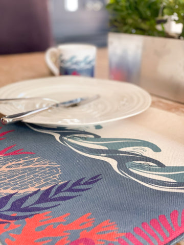 Image of a table set with a placemat with colourful wave and coral design.