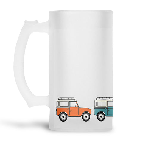 Glass beer stein with an illustration of landrover defenders in different colours arount the bottom.