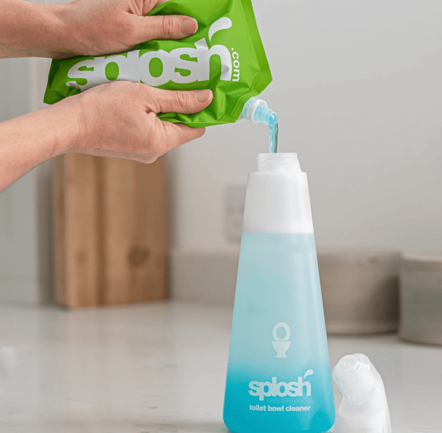 Hands refilling Splosh's blue toilet bowl cleaner