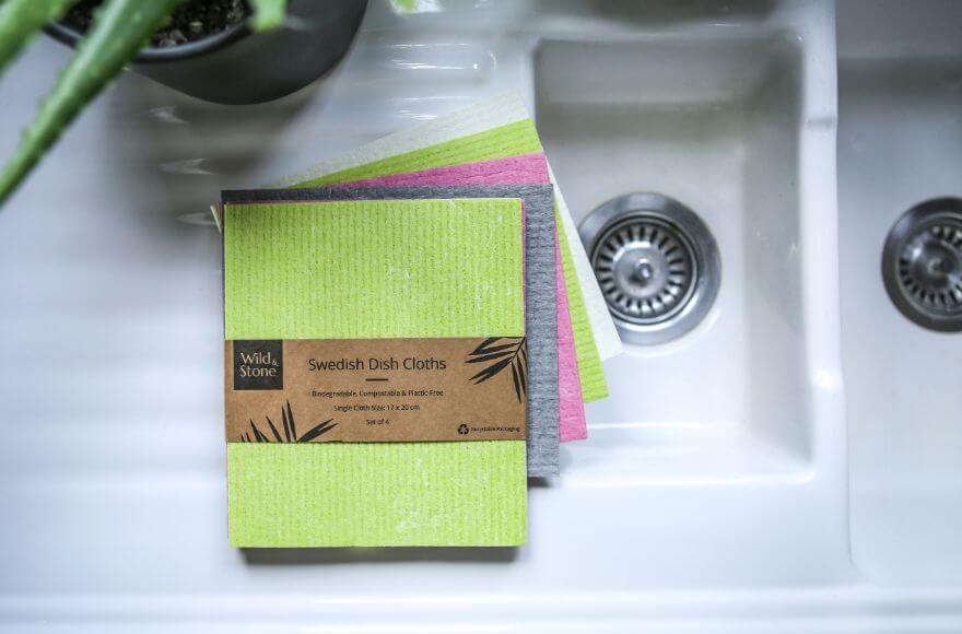 A pack of Wild & Stone's Swedish Dish Cloths on a white sink next to an aloe vera plant.