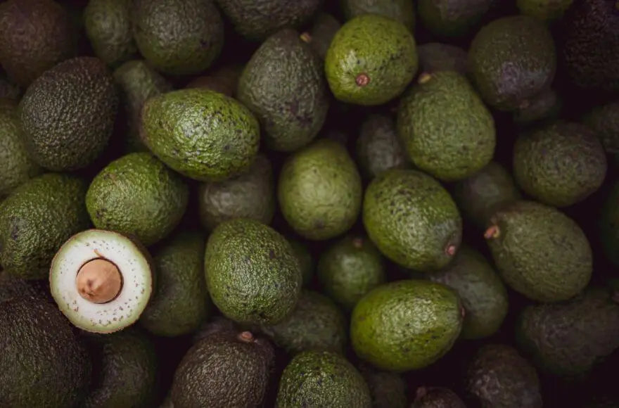 A pile of avocados at a food market.