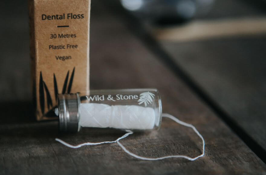 Wild & Stone's eco dental floss laid on a wooden table.