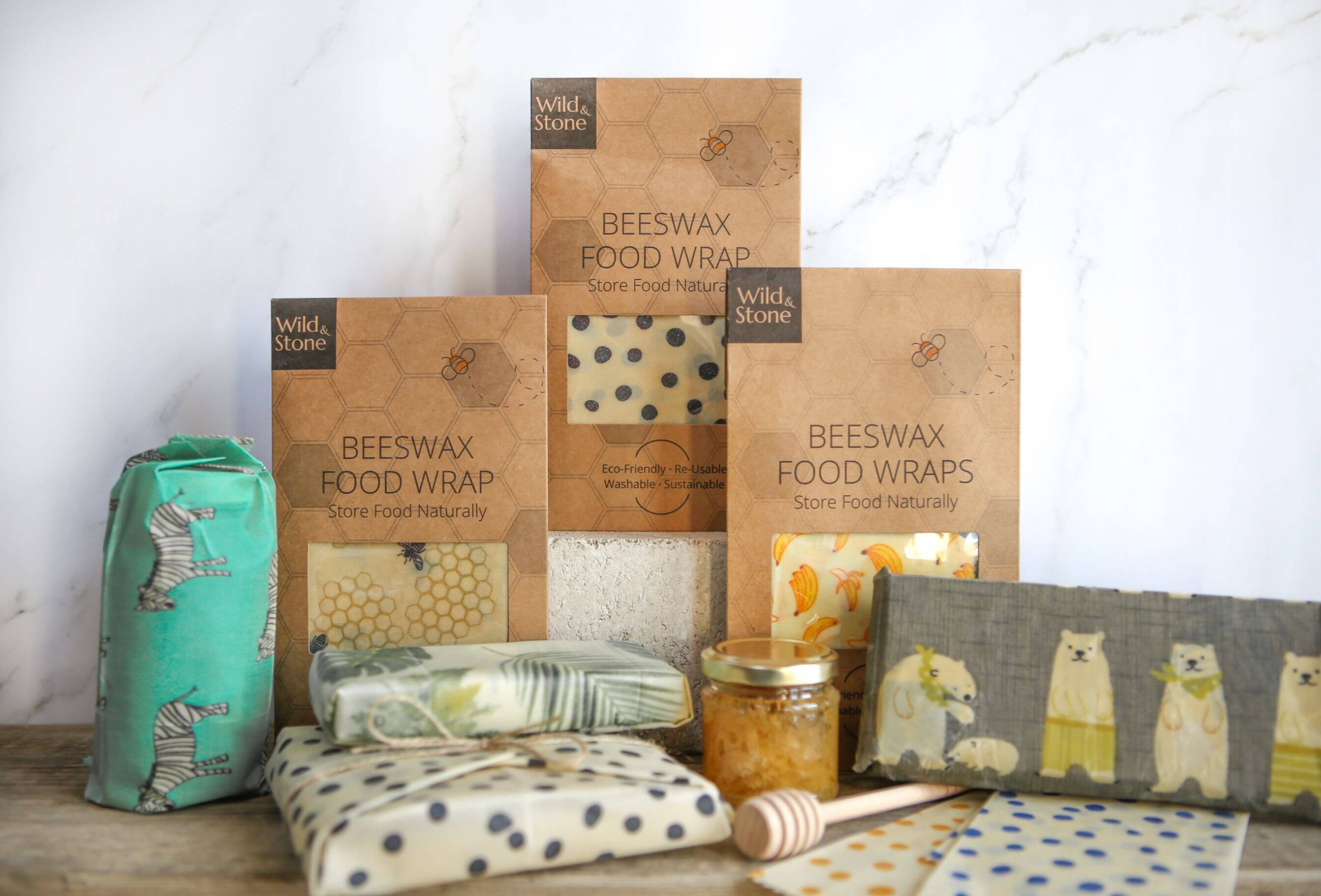 Honeycomb patterned beeswax wraps in a cardboard package sitting on a marble background.