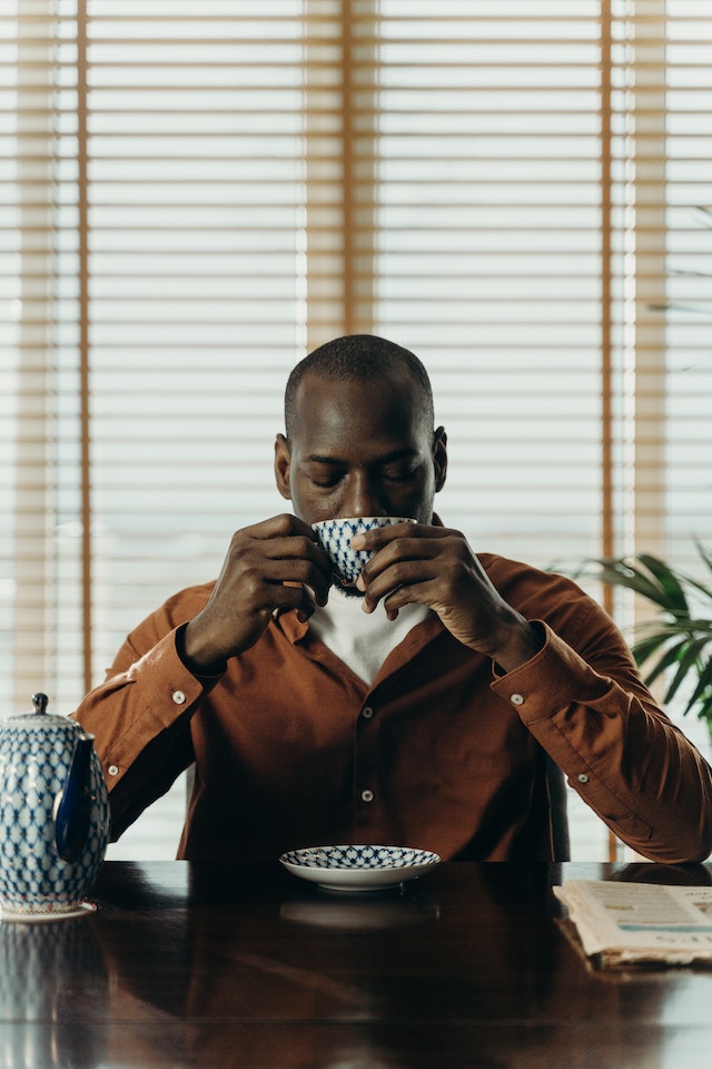 man drinking tea in reflection