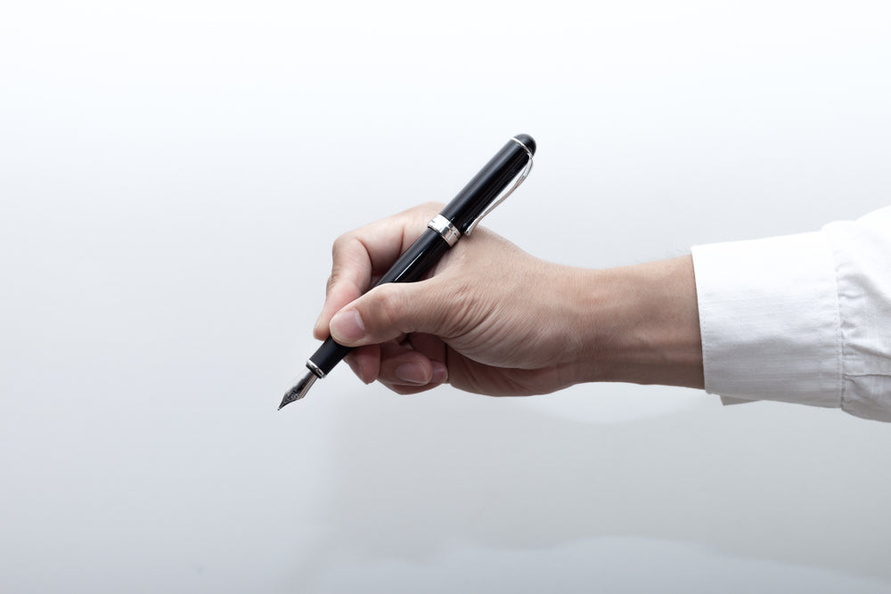 A hand holding a fountain pen