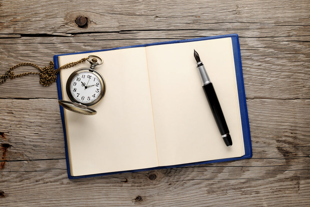 Antique watch and fountain pen on old note book