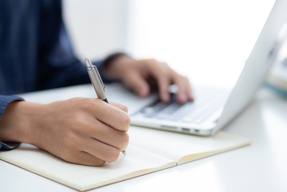 Closeup hand of business man writing on journal