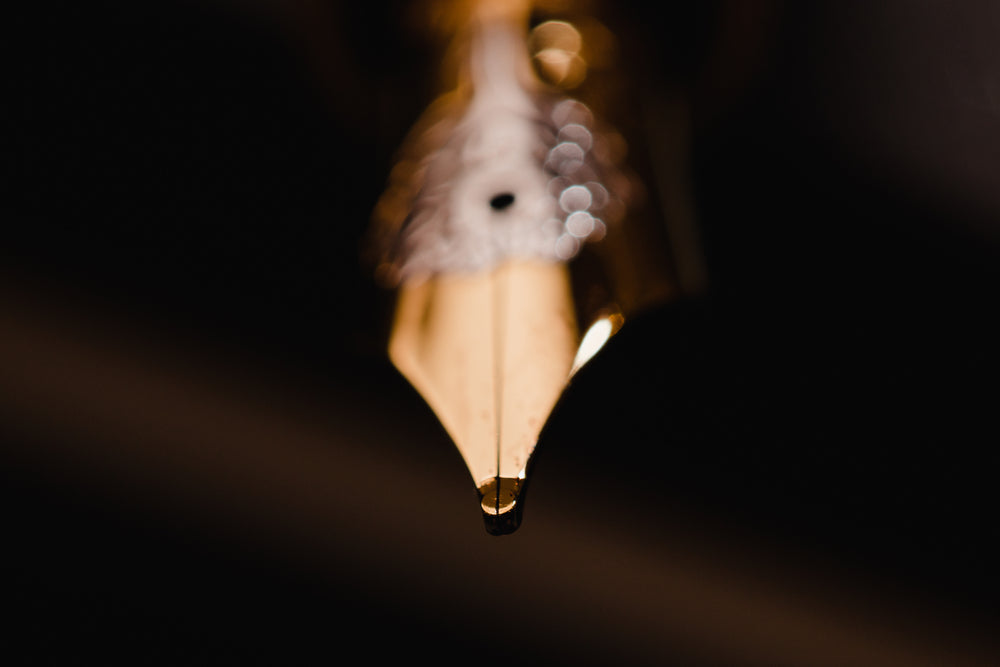 Extreme close up of nib of a fountain pen on dark backround