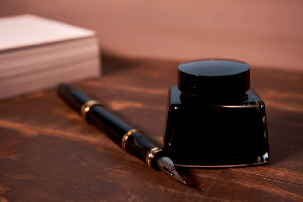 Fountain pen with black ink on wooden table horizontal