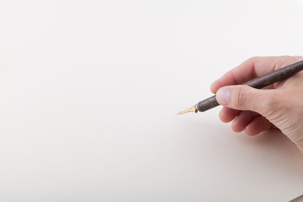 Hand with fountain pen on the white sheet