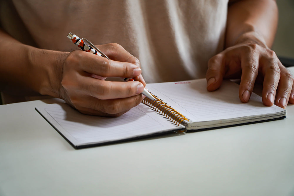 Man hand with pen writing on journal