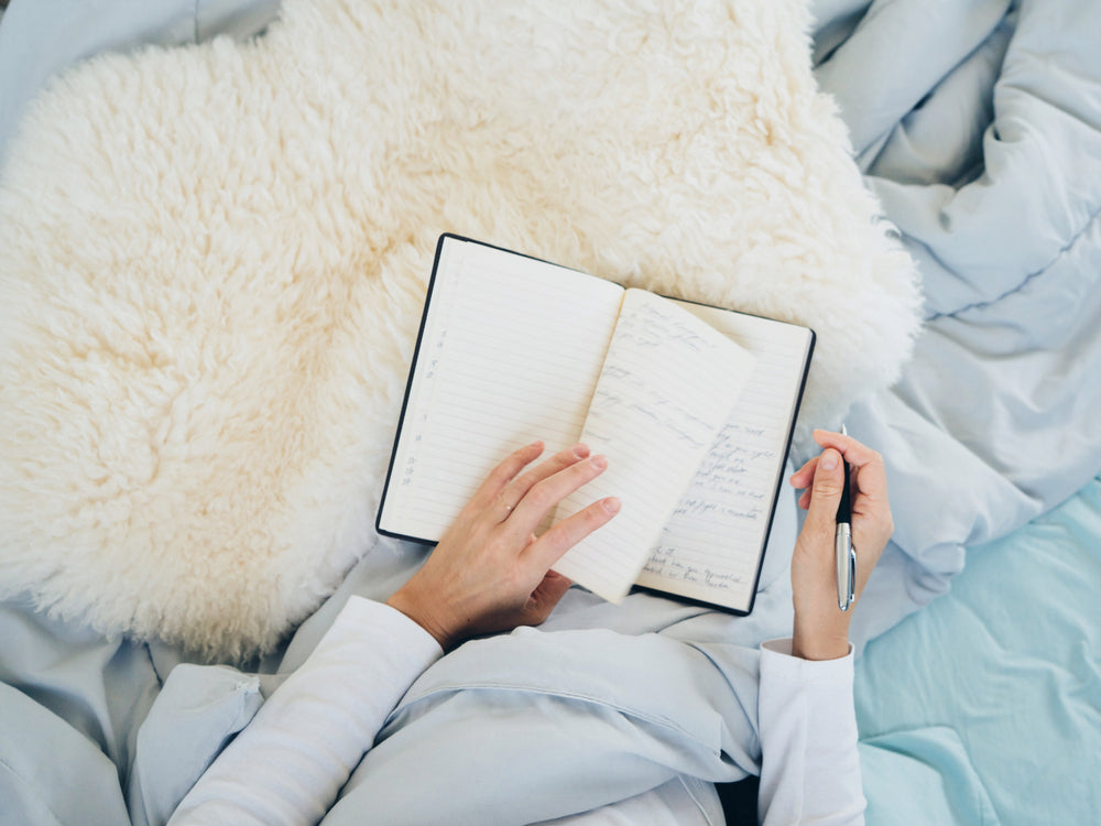 Woman journaling in cozy bed