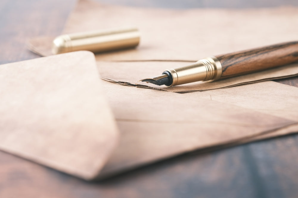 envelope , empty paper and fountain pen on table