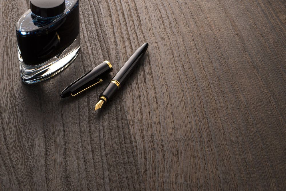 fountain pen and ink bottle on table