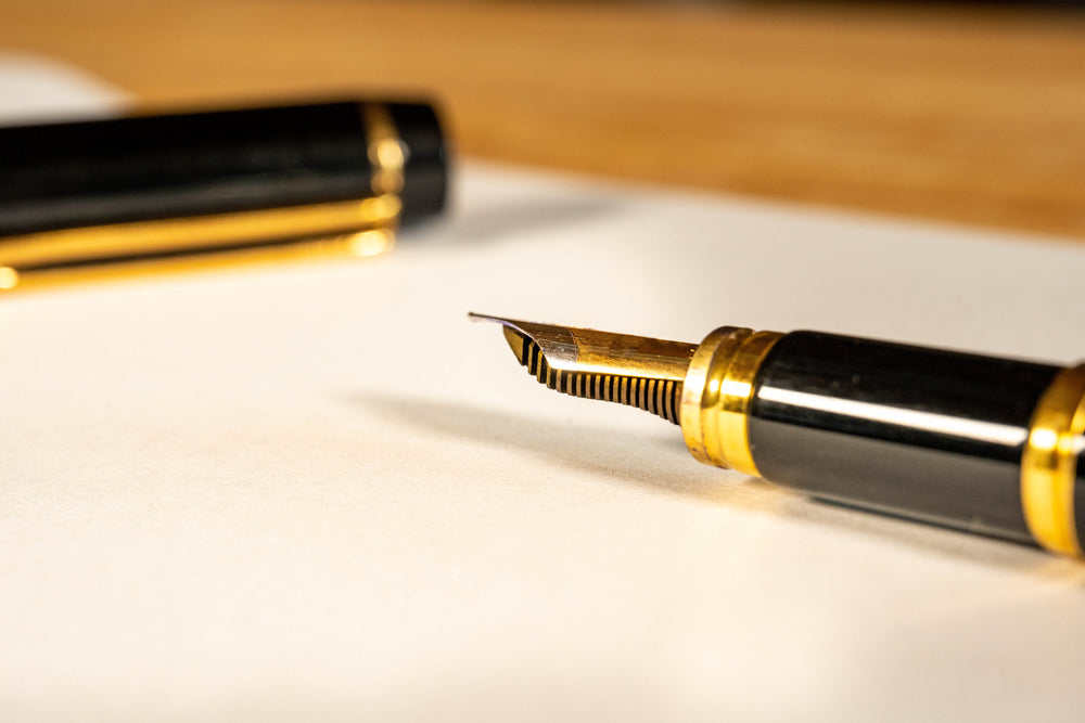 fountain pen is on a desk.