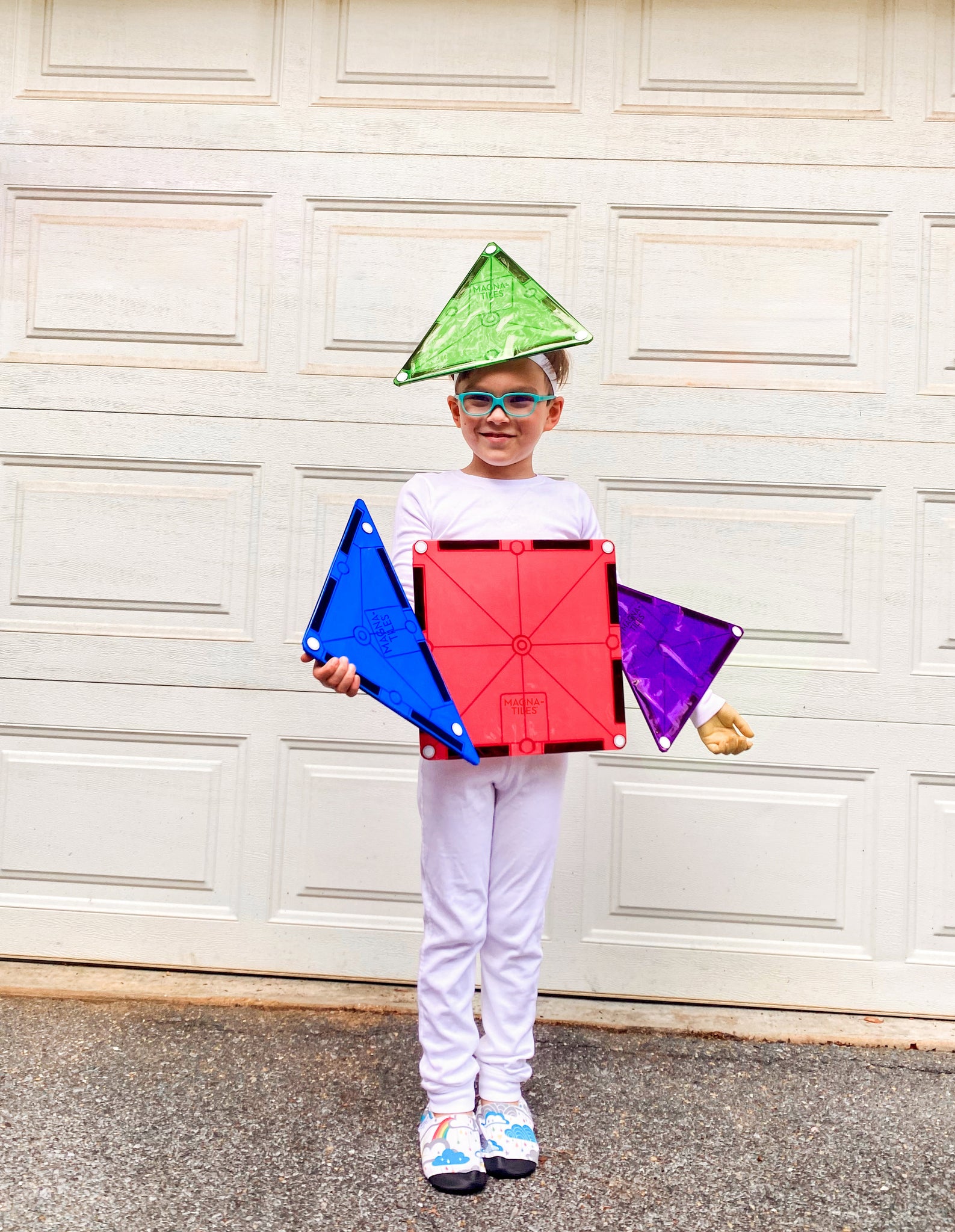 A young boy in white long sleeve pajama separates with DIY MAGNA-TILES Pieces attached to them to make a MAGNA-TILES Halloween Costume