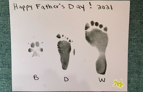 Photo of family footprints in ink that says Happy Father's Day