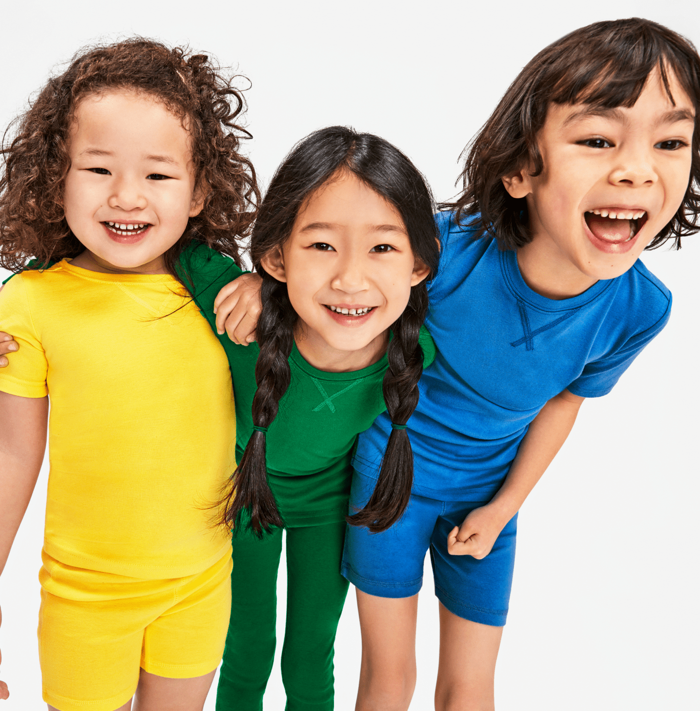 Three kids in pajamas happily laughing together