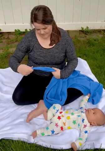 woman using blue muslin swaddle blanket as nursing cover