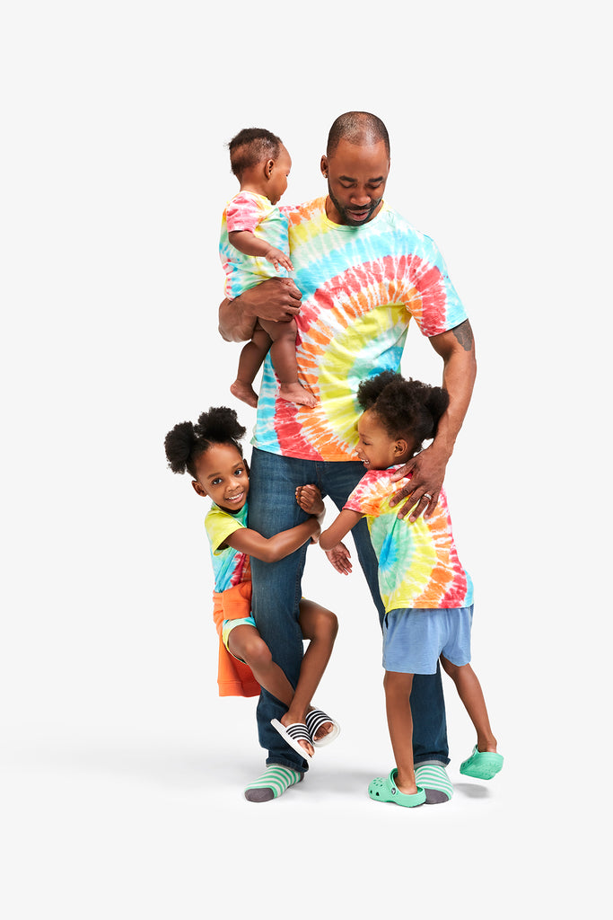 father with three children wearing matching rainbow tie-dye t-shirts