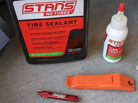 Bottle of Stan's tire sealant and valve core tool