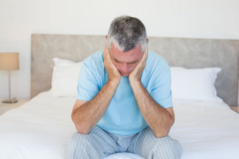Depression leading to resenting sleep, sad senior man sitting on bed