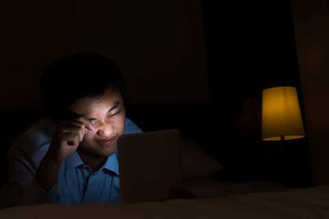 Blue light before bed, man looking at tablet screen before sleeping