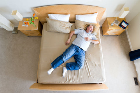 Combine two twin beds into a king, man enjoying lying on a king size bed