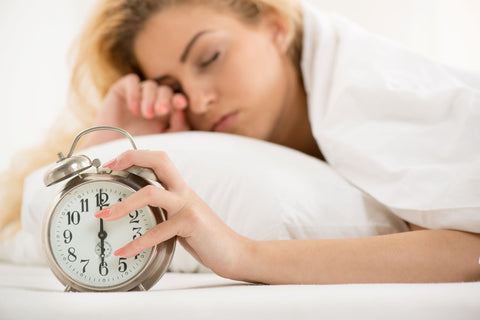 Avoid sleeping in and getting too much sleep, woman sleeping in and turning off alarm clock