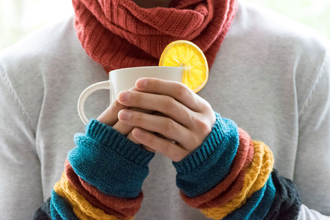 Hot water with lemon and honey for better sleep during the flu, person drinking a cup of hot water with lemon