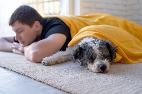 young man sleeping with his dog comfortably on the floor