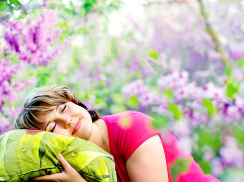 Natural desinfecting of pillow via sunlight, woman outside on pillow with lavender in background