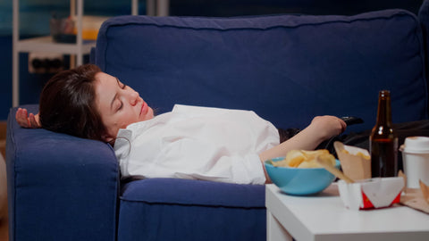 Why does food make you sleepy, woman sleeping on couch after eating