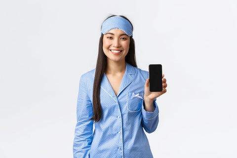 How accurate are the tracked sleep data - women in pajamas holding phone with sleep data