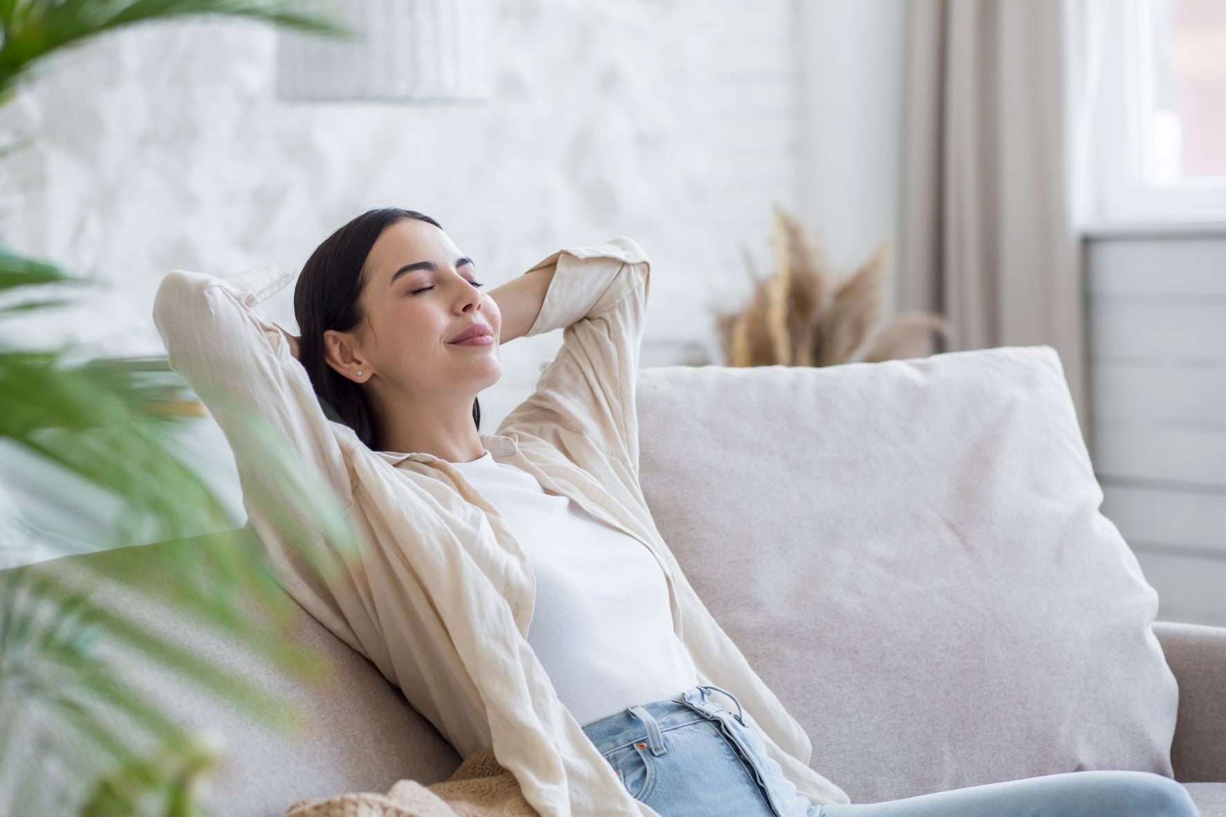 Practice deep breathing before falling asleep; woman practicing breathing techniques before dozing off on couch