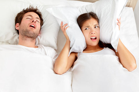 What are the other symptoms of sleep apnea, couple in bed with snoring man and woman covering her ears