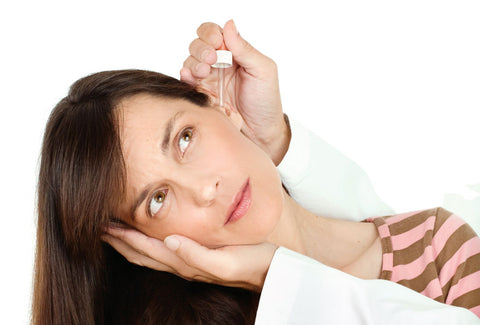 Remedies for ear infections, woman getting ear medication