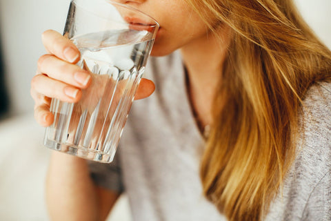 Drink plenty of water if you have a stuffy nose, woman drinking glas of water